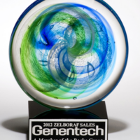 Main Image of Art glass disk with blue and light green accents on black glass base with felt bottom.